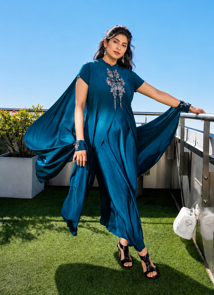 Woman in a blue posh pari dress standing on a nyc rooftop with a clear blue sky.